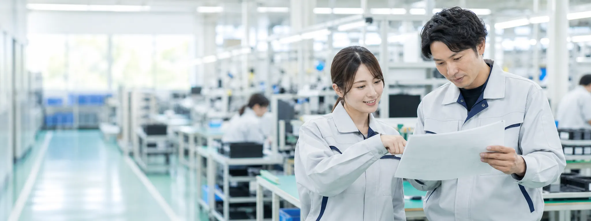 製造現場で作業内容を確認するスタッフ二人